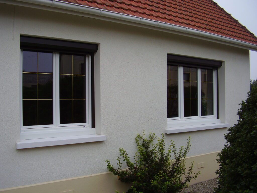Vue d'ensemble des Fenêtres PVC avec oscillo-battant, double vitrage clair et petits-bois alu laiton.