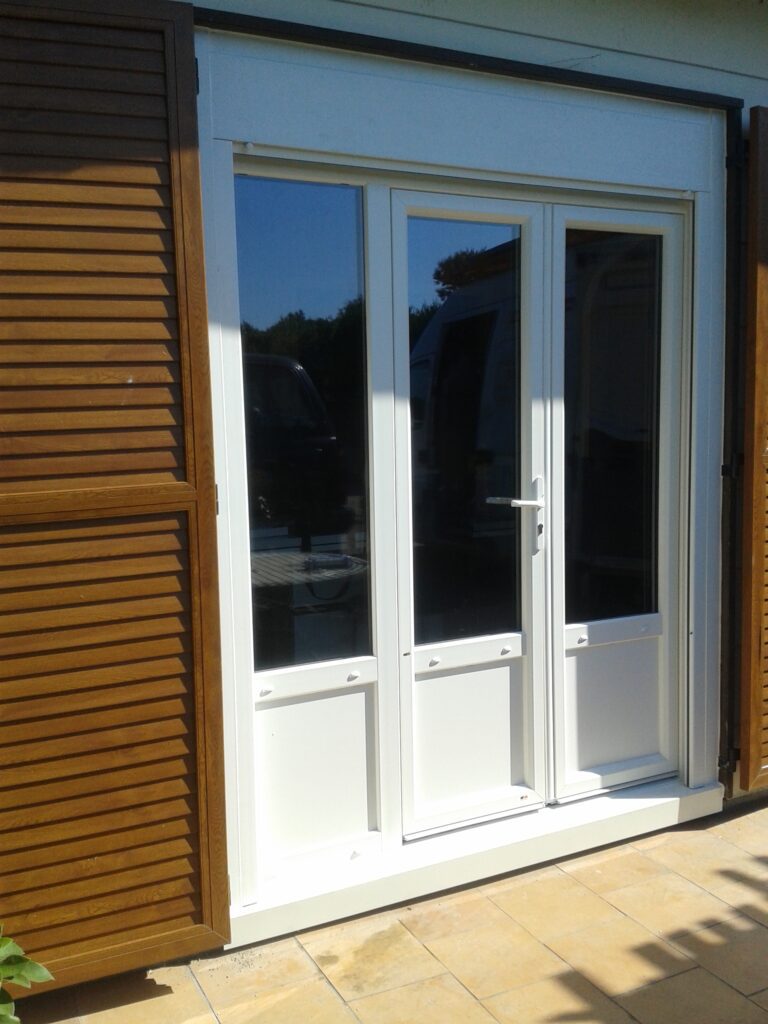 Vue extérieure de la porte-fenêtre PVC double vantaux et fixe latéral.