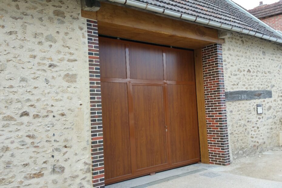 Porte de garage coulissante sur mesure avec portillon intégré, coloris chêne miel, ossature en tube à ailette.