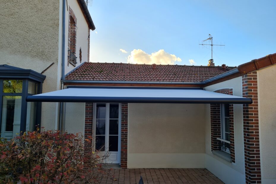 Store Félicia ouvert – armature gris anthracite, toile blanche déployée.