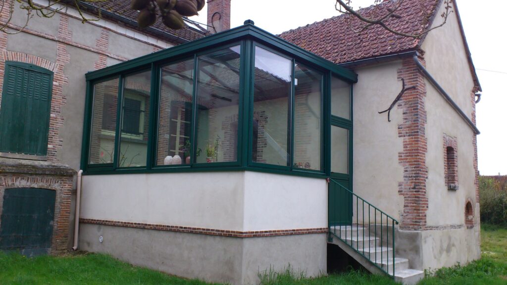 Vue d’ensemble de la véranda aluminium avec châssis coulissants 2 vantaux + porte et finition thermolaquée vert