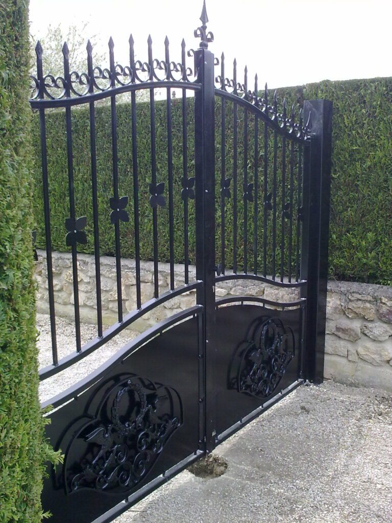 Détail des motifs volutes et oiseaux sur portail acier chapeau de gendarme