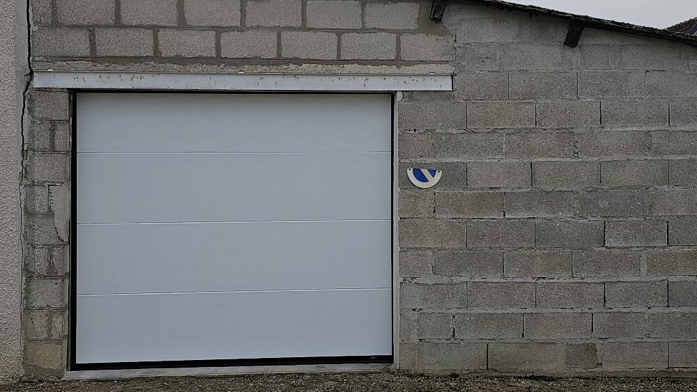 Porte de garage sectionnelle La Toulousaine blanche veiné bois posée par Vaillant Militzer à Romilly-sur-Seine