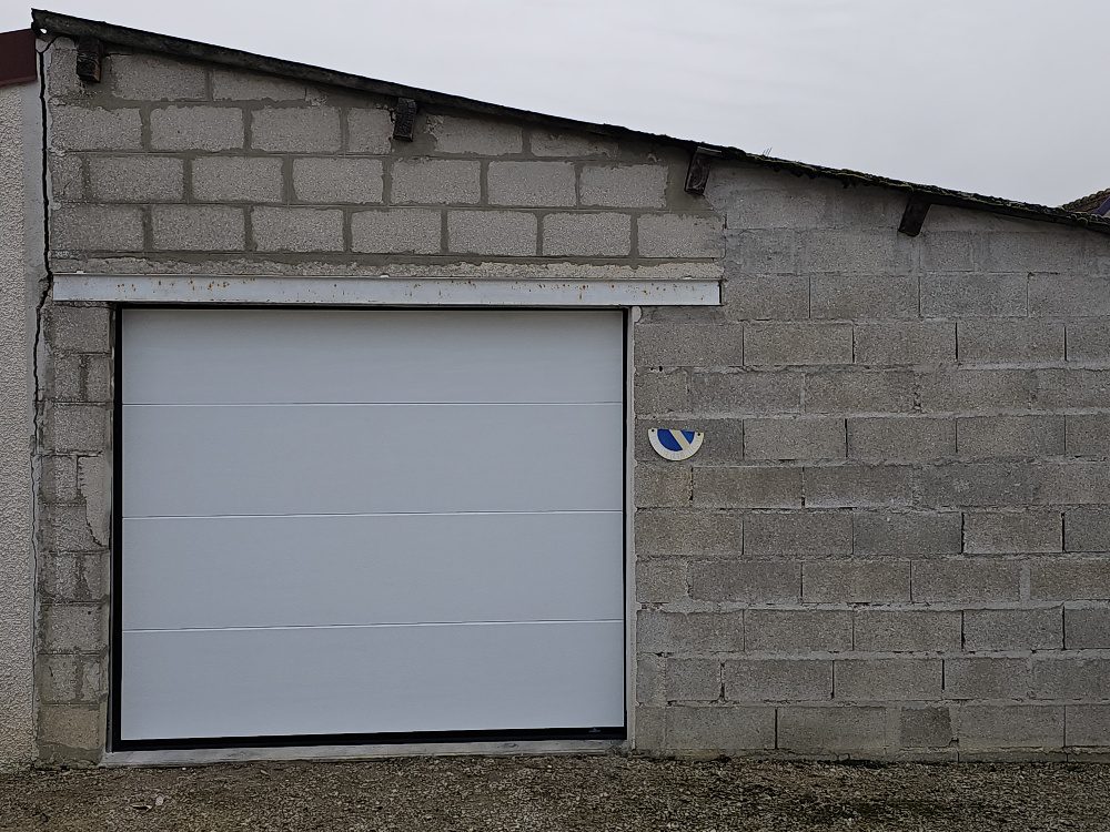 Porte de garage sectionnelle La Toulousaine blanche veiné bois posée par Vaillant Militzer à Romilly-sur-Seine