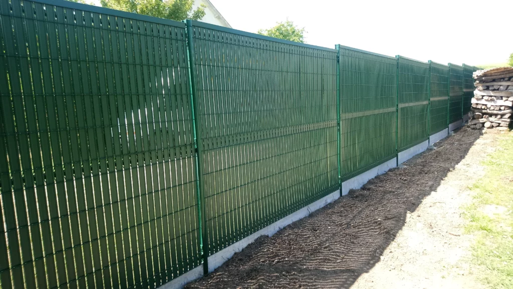 Détail des panneaux occultants plastifiés verts et poteaux scellés