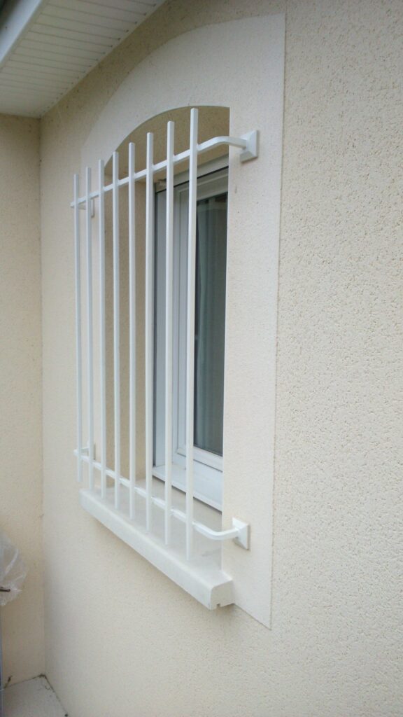 Détail des traverses et fixation sur platines des barreaux de défense en fer blanc