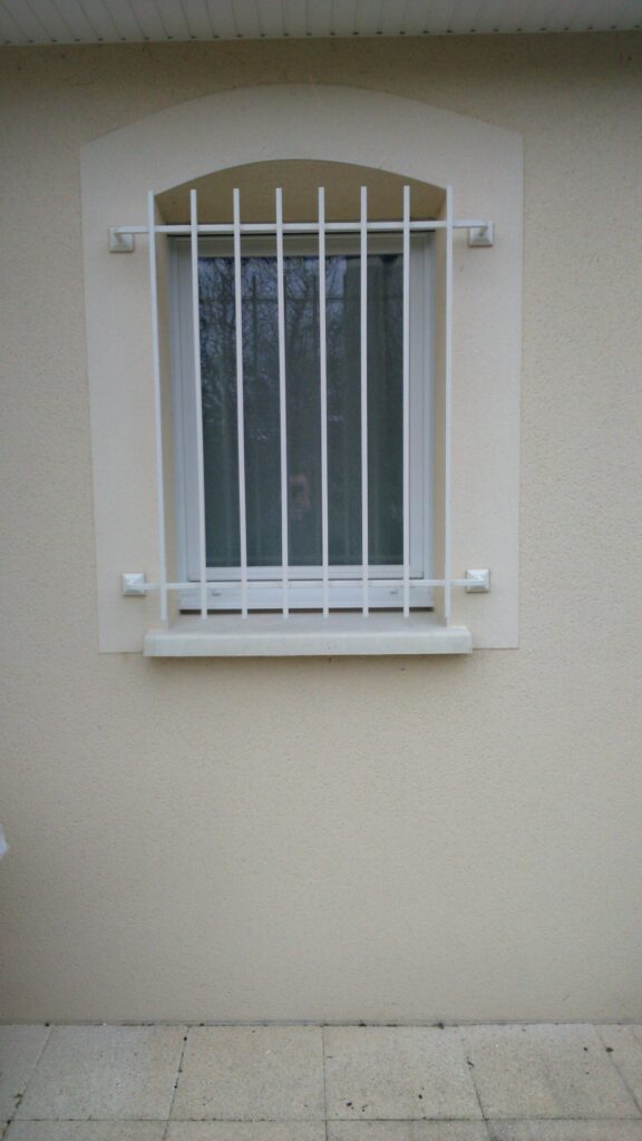 Barreaux de défense en fer carré peints en blanc, fixés sur platines
