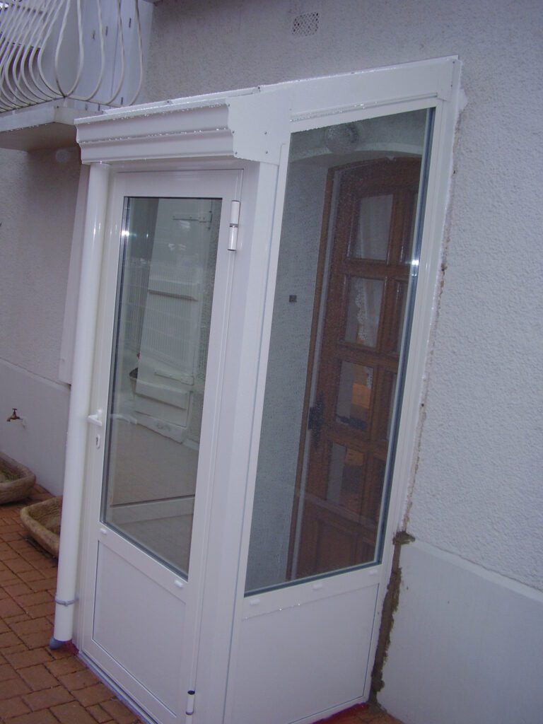 Sas d’entrée vitré en aluminium avec châssis fixes et porte vitrée à isolation renforcée.