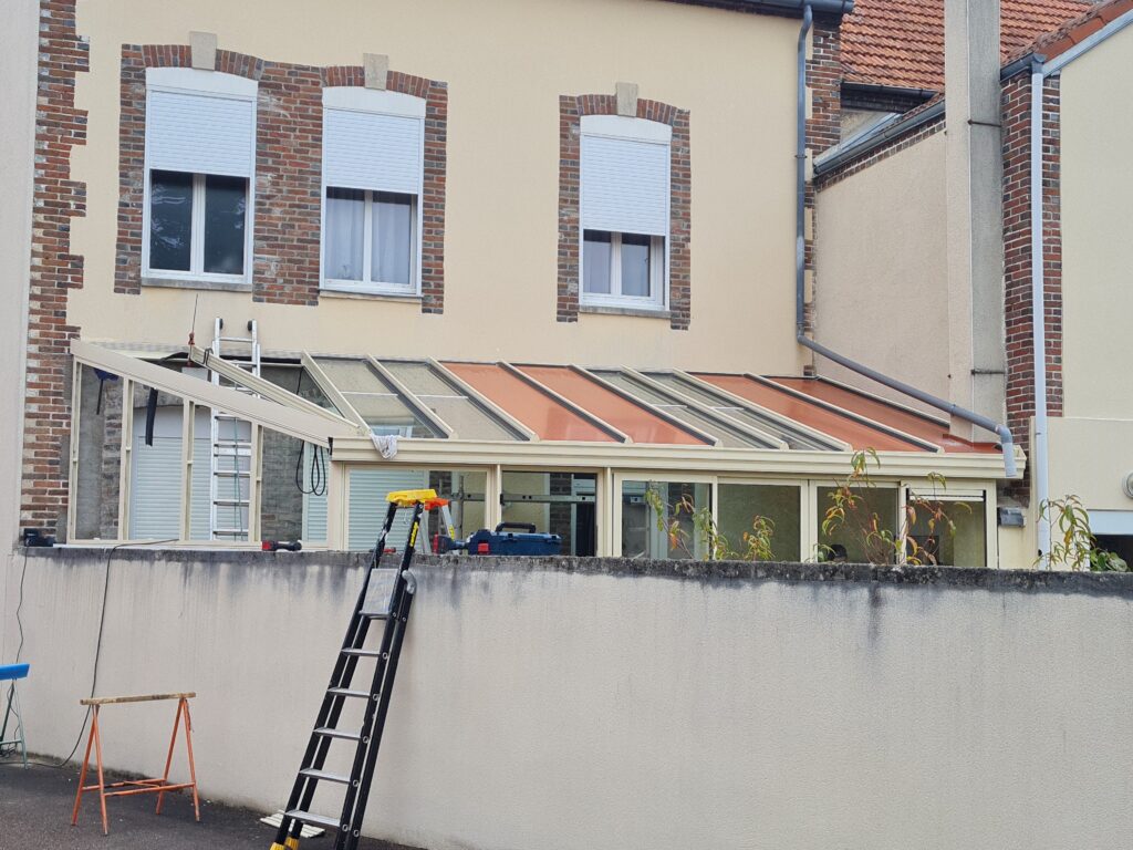 Pose coulissants aluminium véranda sur mesure en cours d’installation