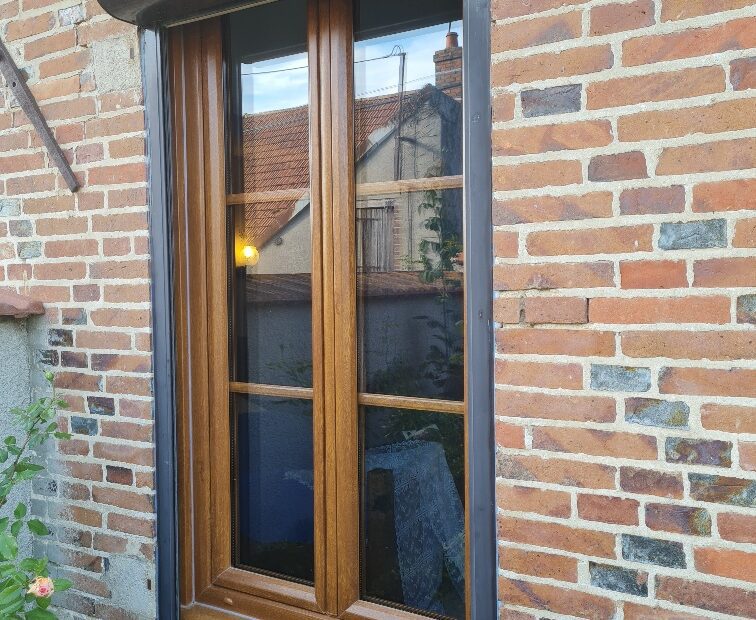 Fenêtre PVC Franciaflex EXCEO Design installée côté rue, finition chêne doré