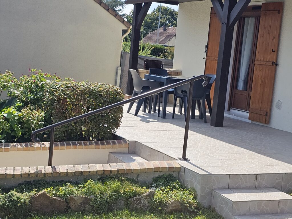 Main courante en tube rond avec poteaux sur platine et crosse arrondie, finition marron RAL 8019