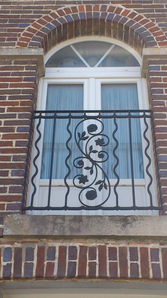 Vue d'ensemble du garde-corps en acier sur mesure avec barreaudage droit et ondulé, grand motif floral et traverses décoratives