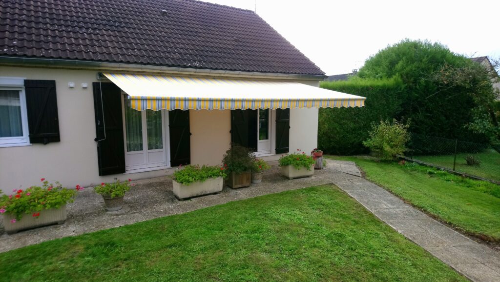 Réentoilage de store banne avec toile acrylique jaune à rayures