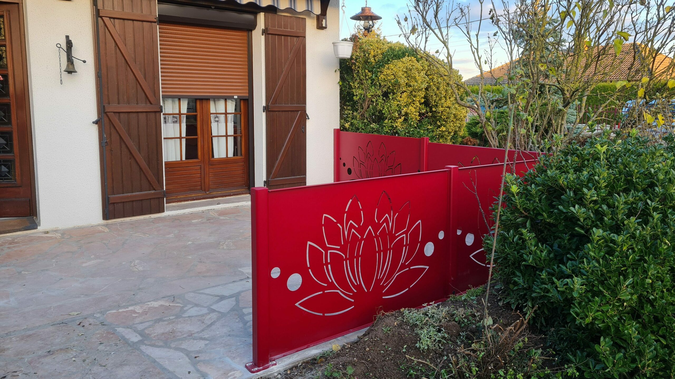 Clôture brise-vue en aluminium motif lotus coloris rouge installée à Romilly-sur-Seine par Vaillant Militzer