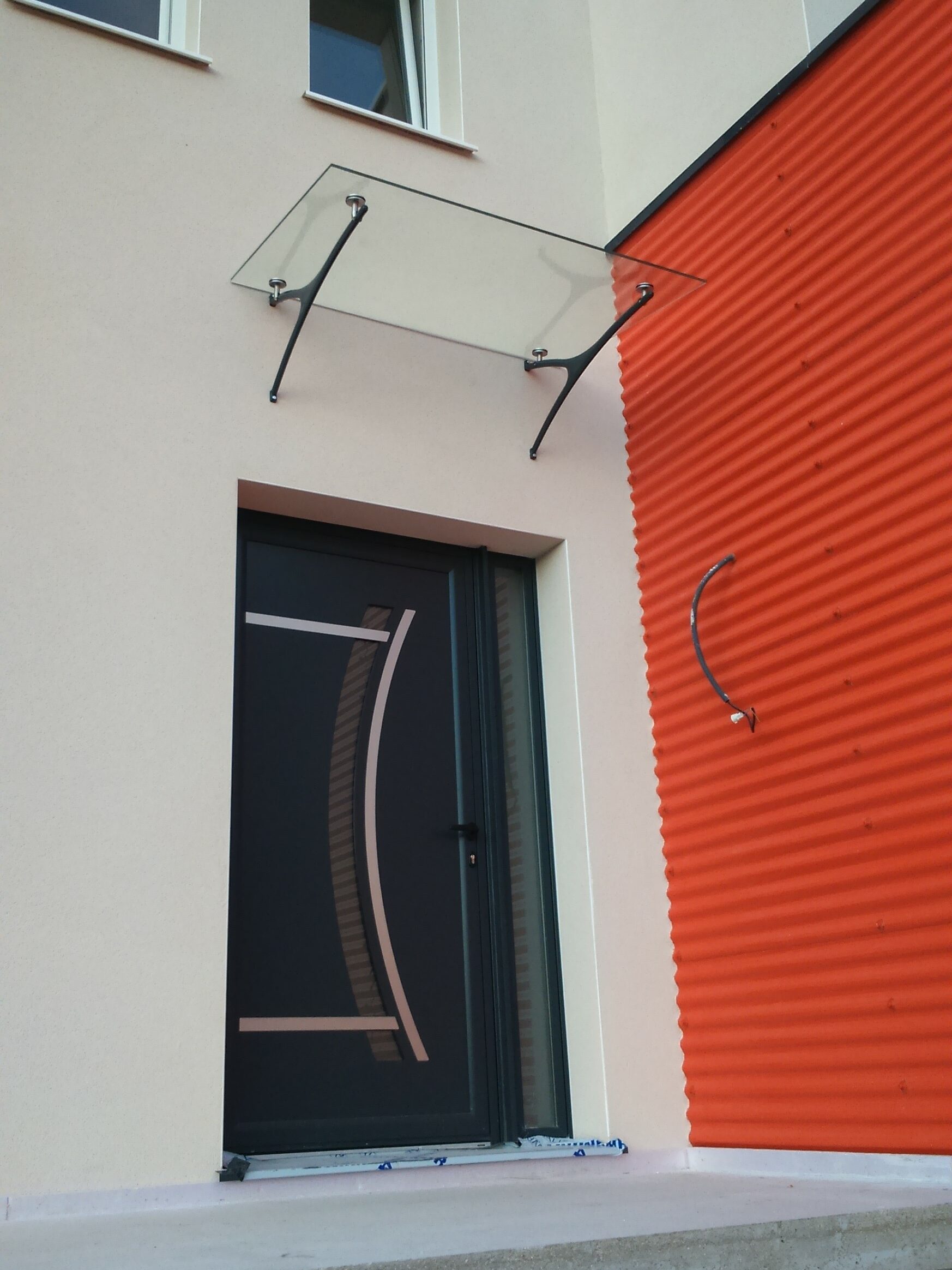 Marquise moderne en aluminium installée au-dessus d’une entrée de maison