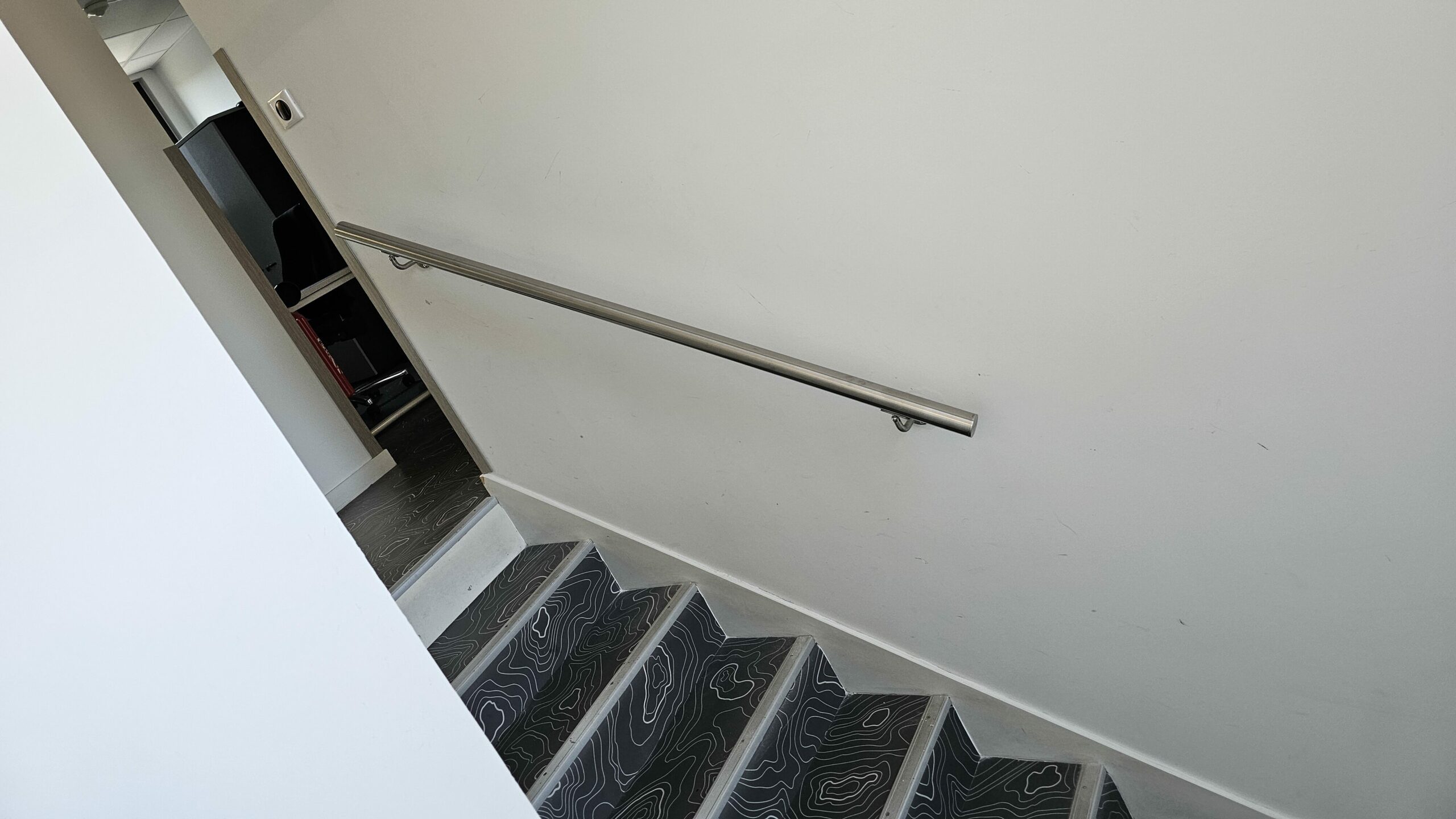 Main courante inox murale installée pour sécuriser un passage