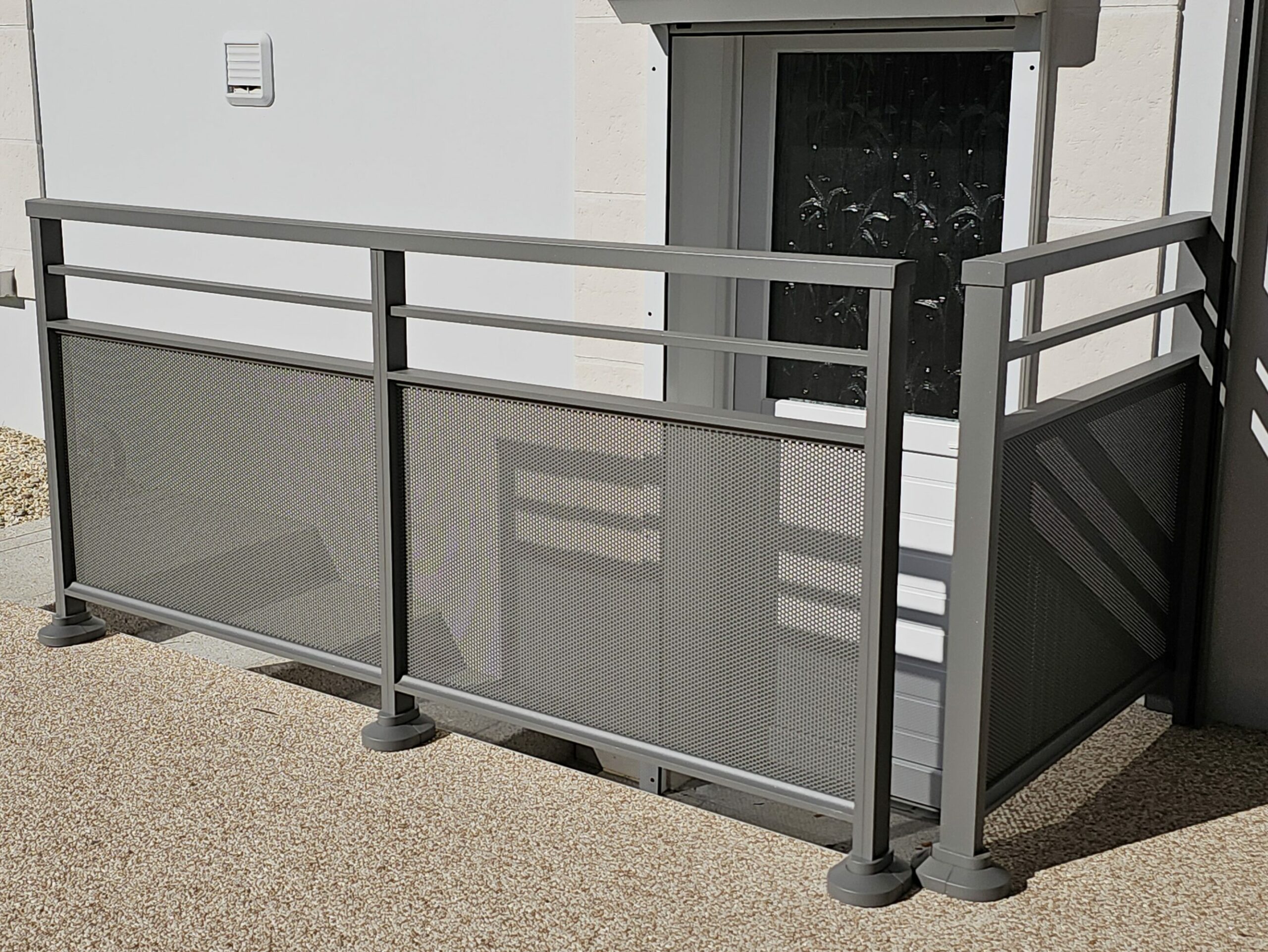 Garde-corps aluminium SIB gris 9007 texturé avec tôle perforée à motifs ronds.