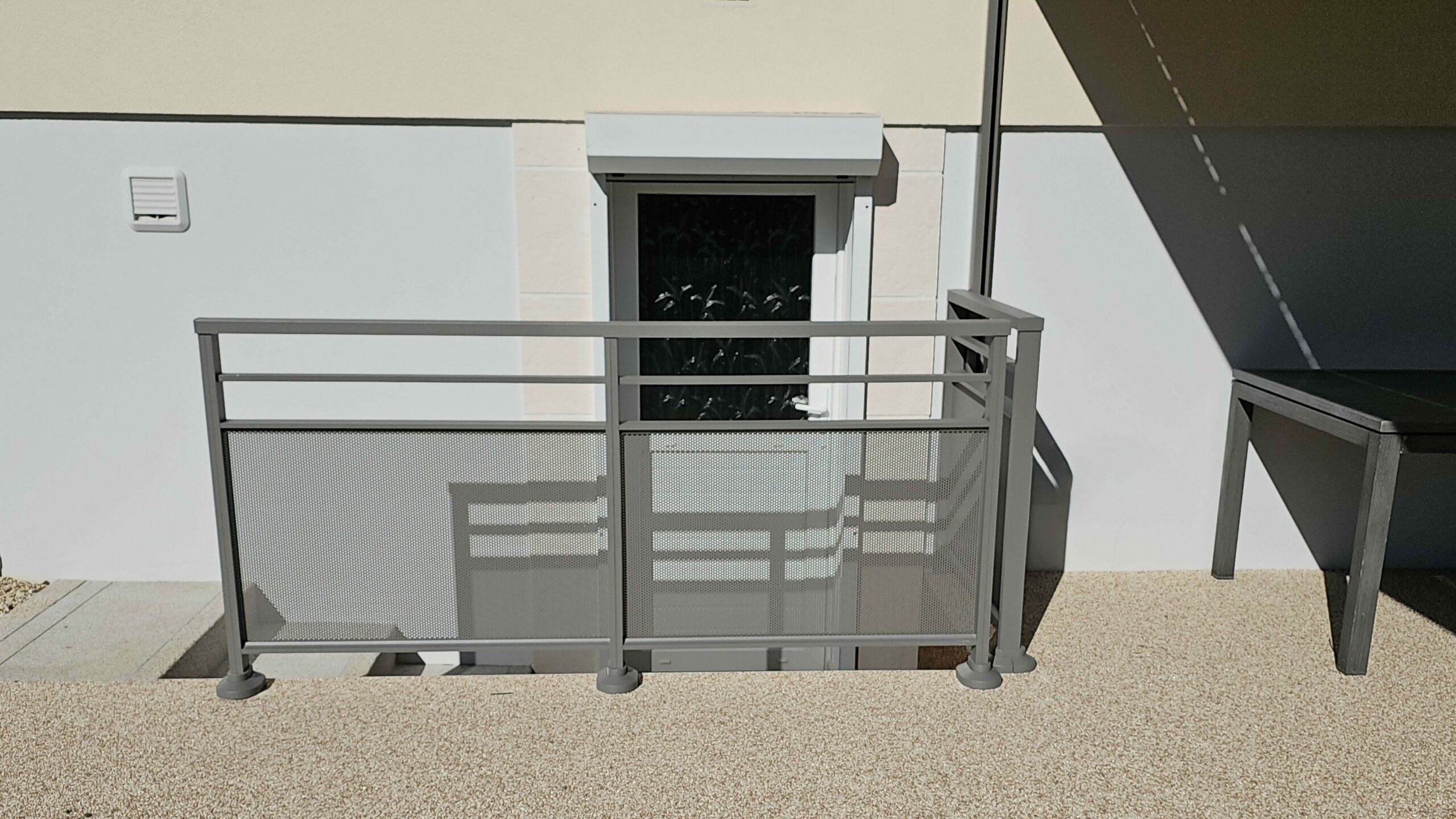 Garde-corps aluminium gris 9007 texturé vu de côté avec remplissage perforé.