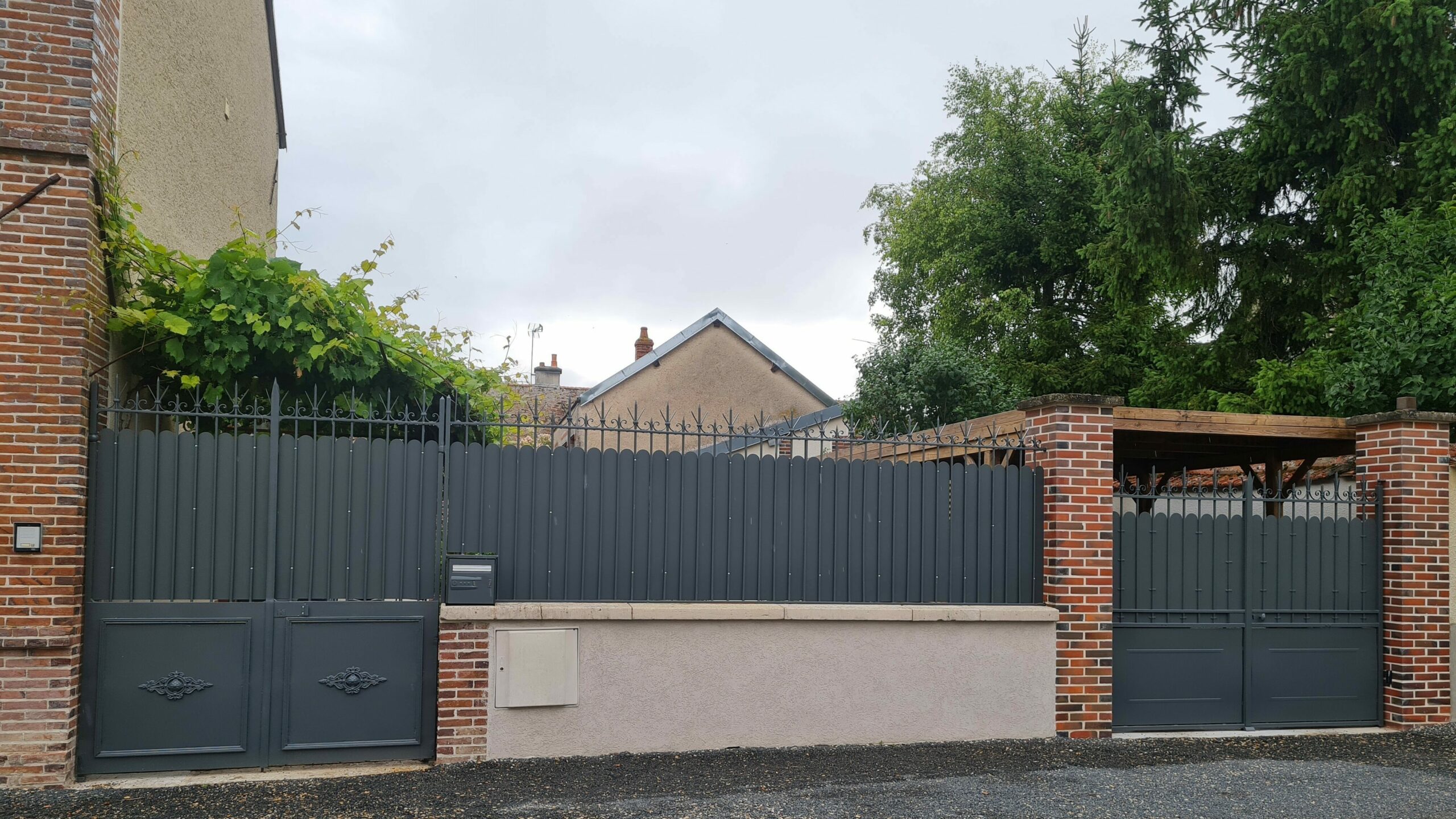 Festonnage métallique gris RAL 7016 installé sur un portail et une clôture existante.